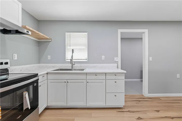 A well-equipped kitchen showcasing elegant countertops and natural wood flooring.