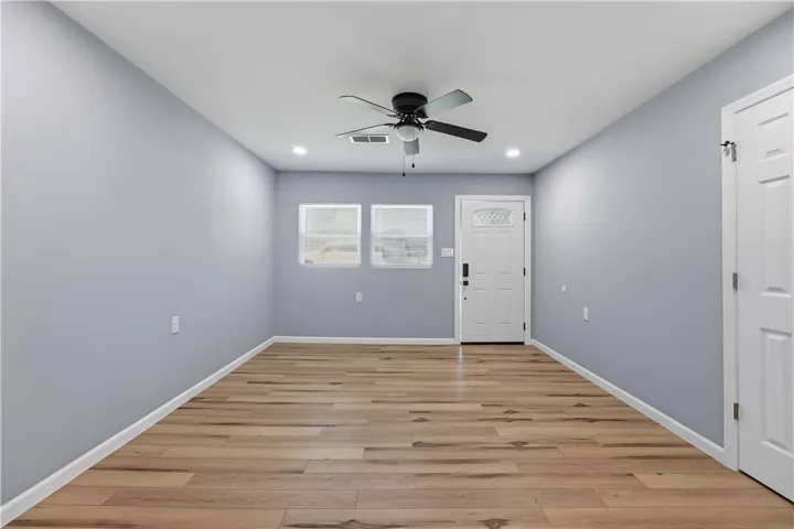 A welcoming entry features durable laminate flooring and a ceiling fan, perfect for any living space.