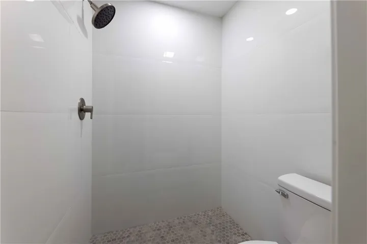 A modern shower space with clean lines and honeycomb floor tiling.