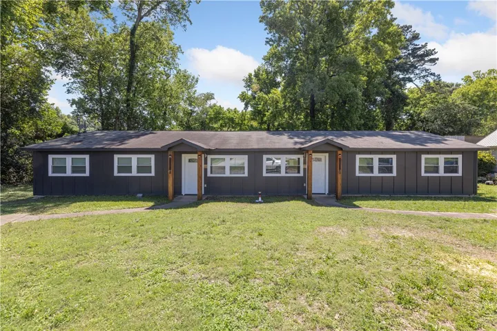 Two identical residential units share a continuous front yard and covered entries.