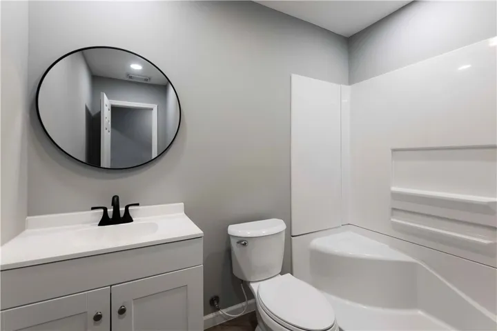 A well-appointed bath features a sleek vanity, modern mirror, and a convenient shower-tub combination.