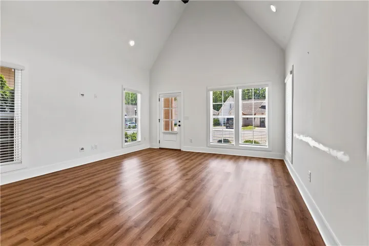 A spacious room offers high vaulted ceilings and naturally illuminated interiors through ample windows.