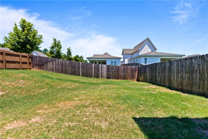 A sloped grassy yard, fully fenced for privacy, provides a perfect outdoor retreat.
