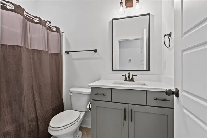A pristine bathroom featuring a sleek vanity and convenient toilet setup.