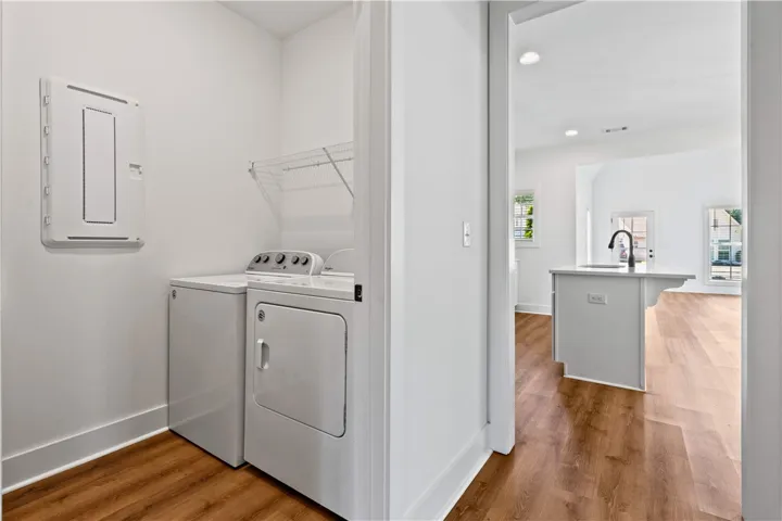 Functional laundry space with convenient shelving transitions to open-concept living.