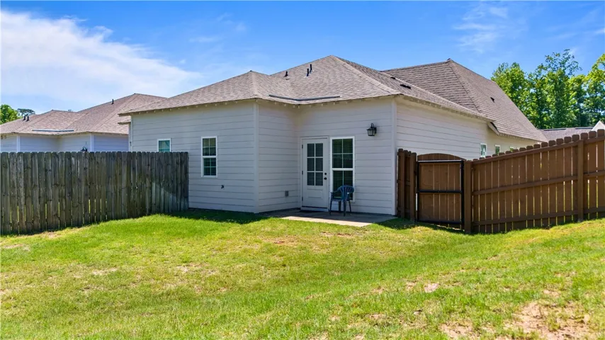 Secure yard featuring a durable wood fence and a small private patio area, perfect for tranquil outdoor moments.