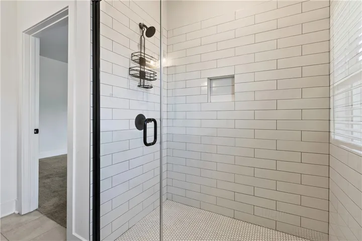 A chic shower with subway tile and glass enclosure creates a clean, functional space.
