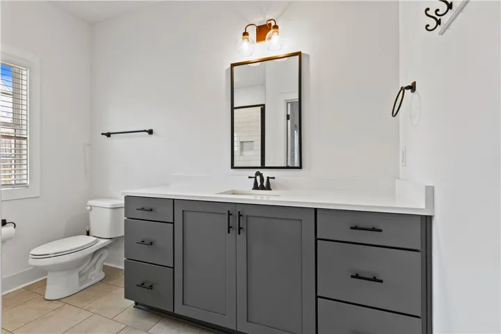 A well-appointed bath features a modern vanity with ample storage and a sleek mirror.