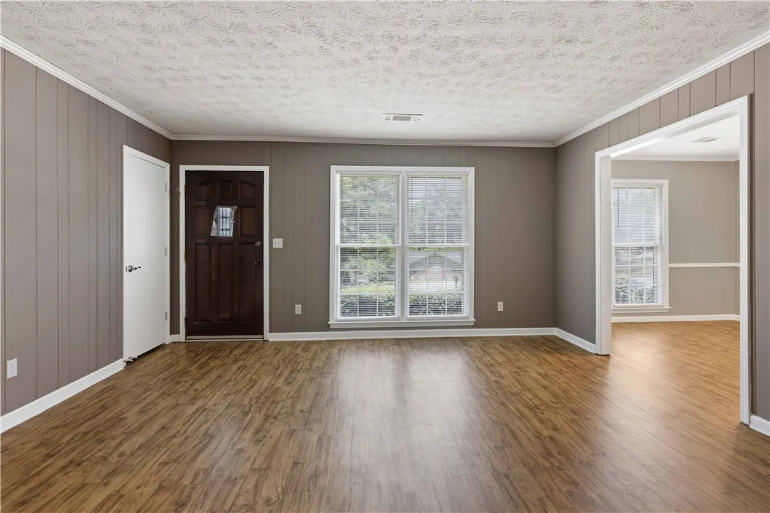 Rich wood floors extend throughout this welcoming entrance, inviting you into a bright and comfortable living area.