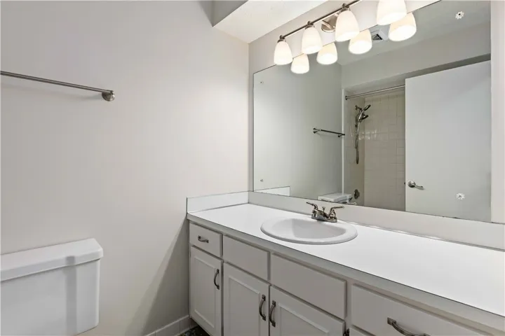 Functional vanity with ample counter space and well-lit mirror offers everyday ease.