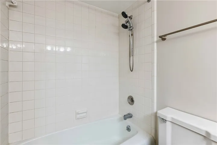 A well-maintained tub and shower with crisp, white tiling awaits in this refreshed bathroom.