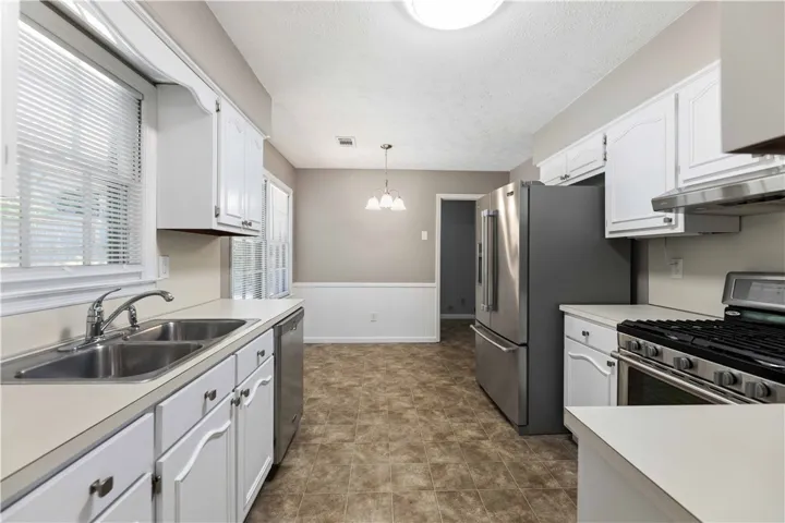 A functional kitchen provides ample counter space, bright cabinetry, and a cozy dining area.