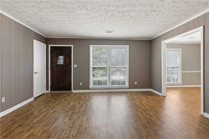 Rich wood floors extend throughout this welcoming entrance, inviting you into a bright and comfortable living area.
