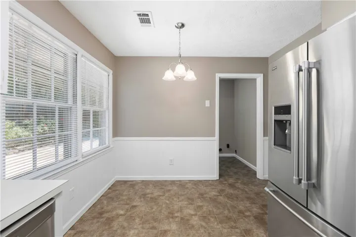 A casual dining space features a polished tile floor and ample natural light.