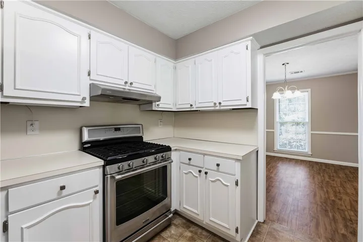 A well-appointed kitchen features ample cabinetry and a gleaming stainless steel range.
