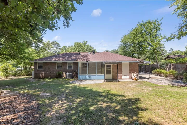 A well-maintained backyard with a screened-in porch offers tranquil outdoor living.