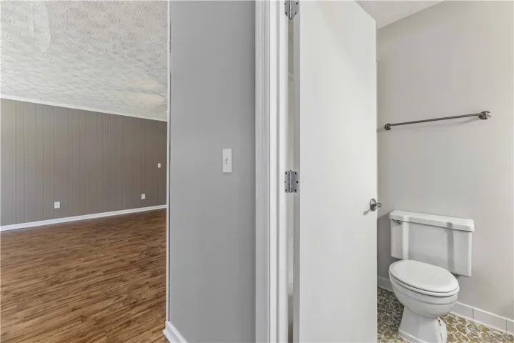 Clean and functional bathroom with wood plank flooring extending to adjacent living space.