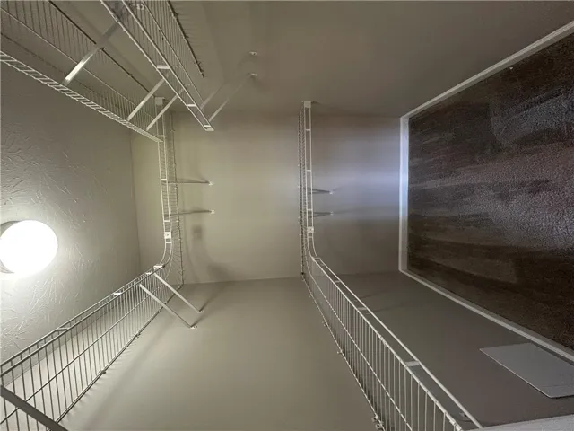 Well-lit walk-in closet with ample shelving provides generous storage space.