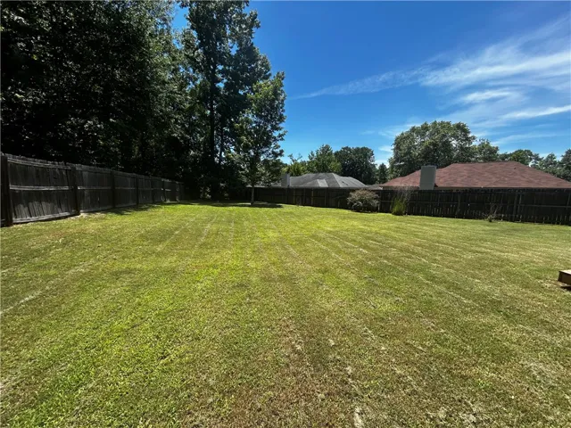 Ample green space with perimeter fencing, providing privacy and outdoor enjoyment.