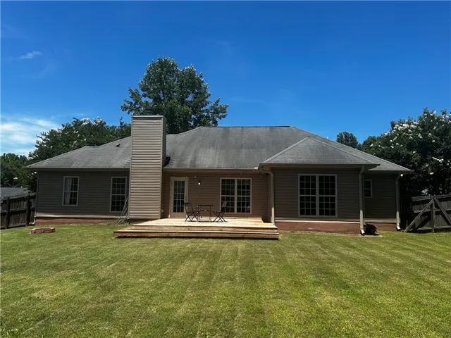 An inviting wooden deck extends into a private yard, perfect for outdoor leisure.