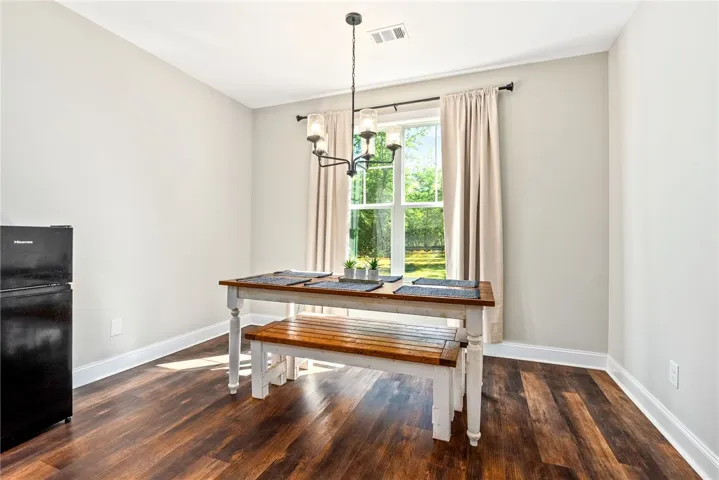 Hardwood floors and a chandelier illuminate this cozy dining area, perfect for intimate meals.