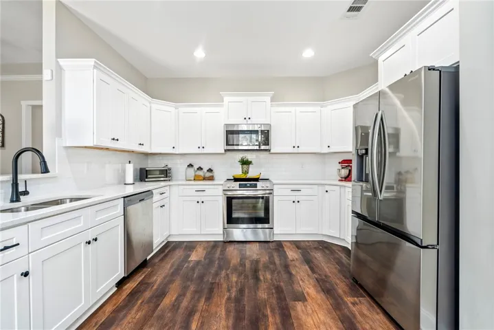 Bright white cabinetry and subway tile backsplash elevate this inviting culinary space.