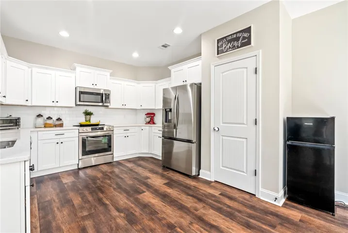 Bright white cabinetry and stainless appliances create a functional and inviting kitchen space.
