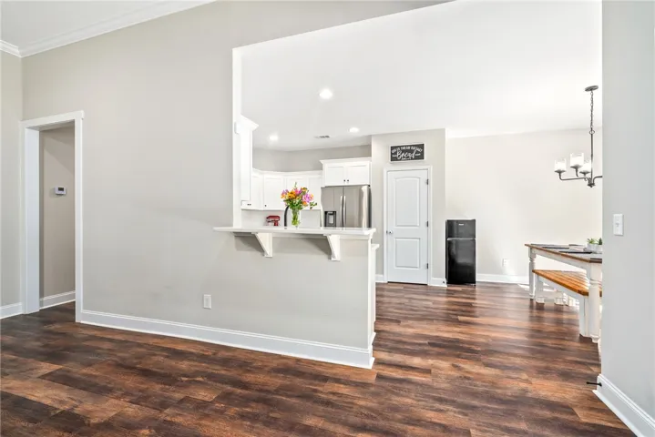 An open floor plan with rich wood flooring connects the bright kitchen and dining space.