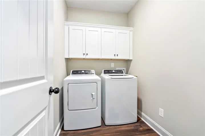 Functional laundry zone with convenient overhead cabinetry for seamless organization.