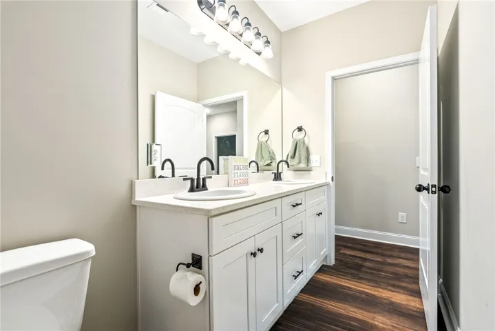 Double vanity with sleek fixtures offers a convenient and organized space.