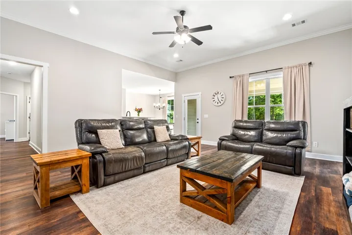 A spacious living area with hardwood floors transitions smoothly to an inviting kitchen, perfect for entertaining.
