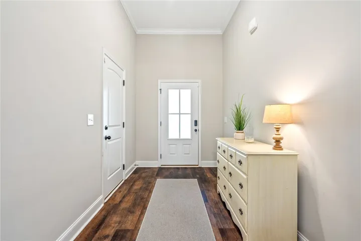 A well-lit entry hall with rich hardwood flooring and an inviting front door.