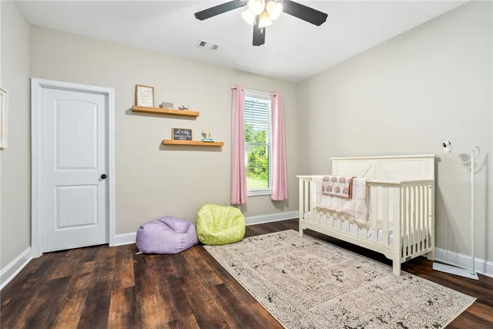Rich hardwood-style flooring and a ceiling fan provide comfort in this peaceful room.