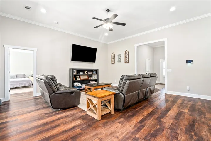 A comfortable living space boasts durable flooring and recessed lighting, ready for quiet enjoyment or lively gatherings.