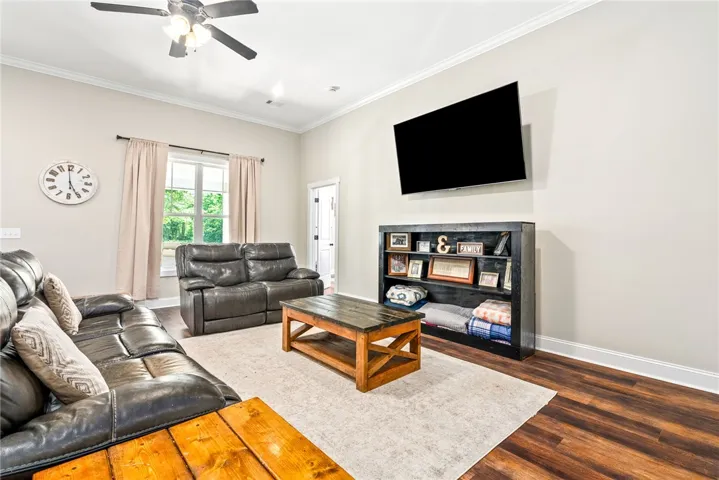 A comfortable living area featuring rich wood flooring and crown molding, perfect for relaxation.