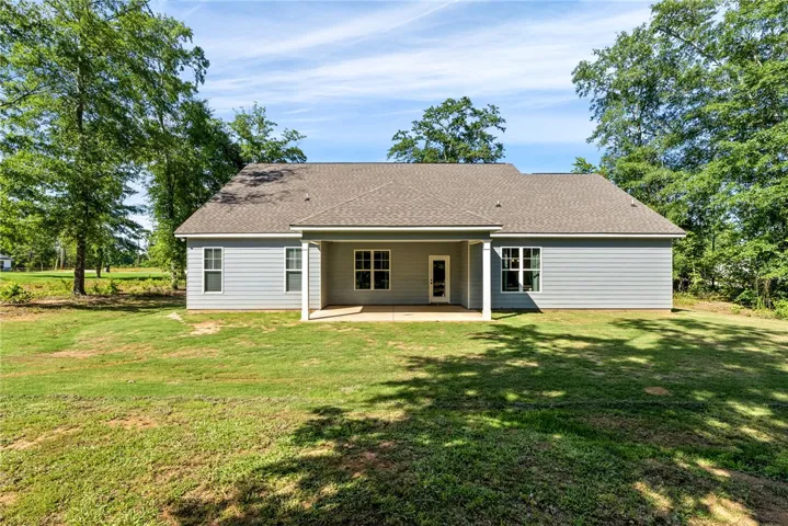 A private rear yard with a covered patio offers seamless indoor-outdoor living.