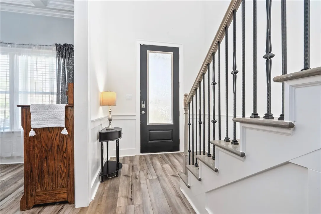A welcoming entry features durable flooring, a well-crafted staircase, and bright, clean walls.