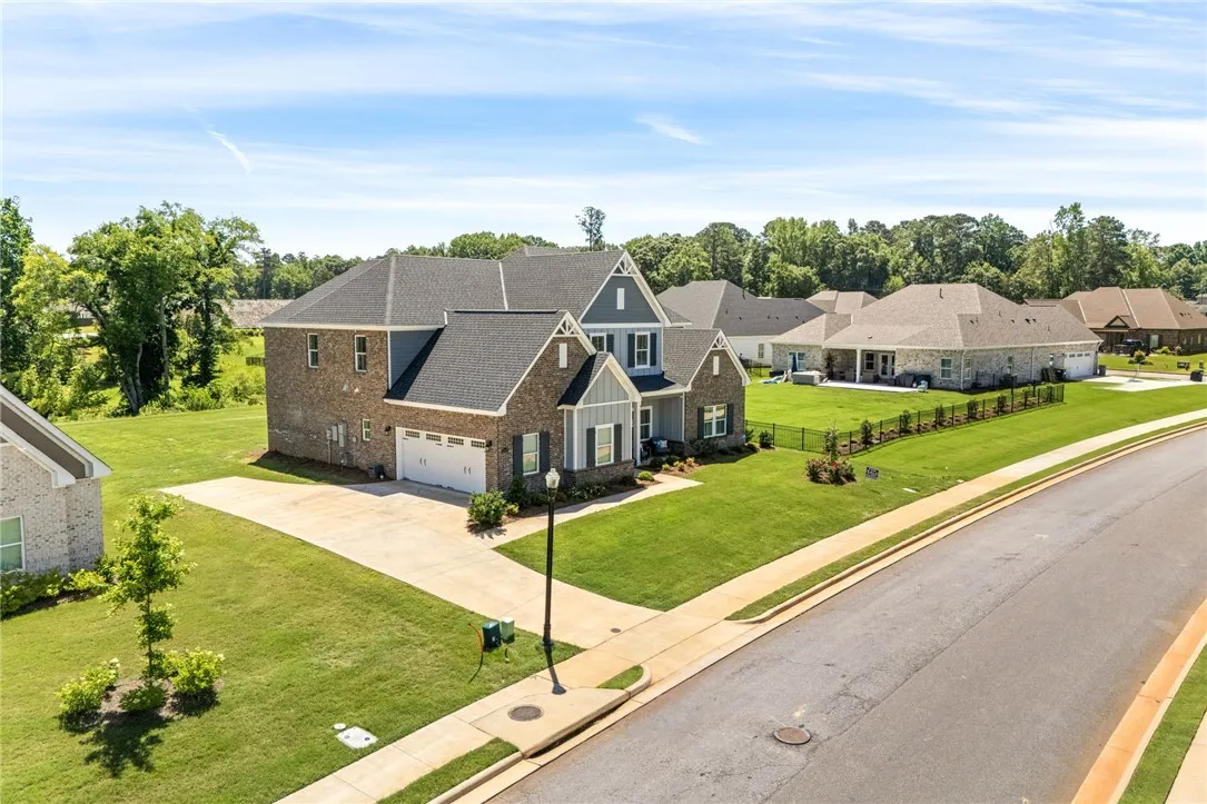 A grand residence featuring an attached garage and meticulous landscaping.