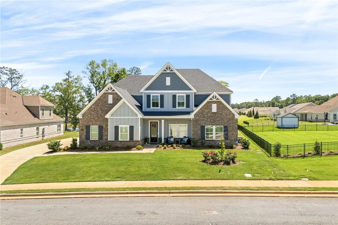 Crafted with brick and siding, this charming residence offers a welcoming street presence with a verdant lawn.