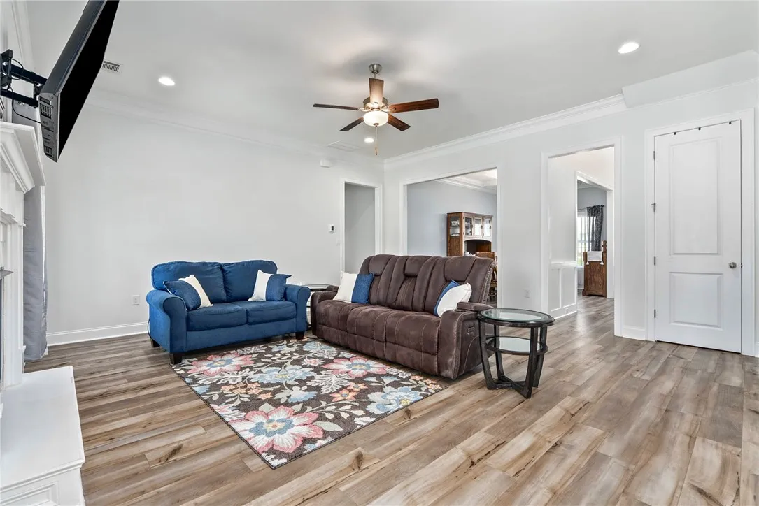 A well-lit gathering space with wood flooring and recessed lighting.