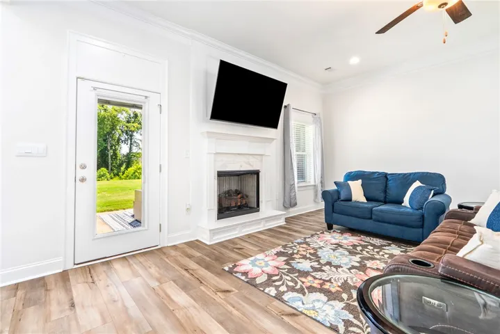 A refined living space showcasing warm flooring and a classic fireplace.