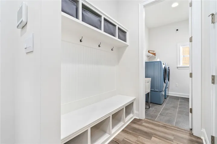 A well-appointed laundry area offers practical built-in storage solutions and durable flooring.