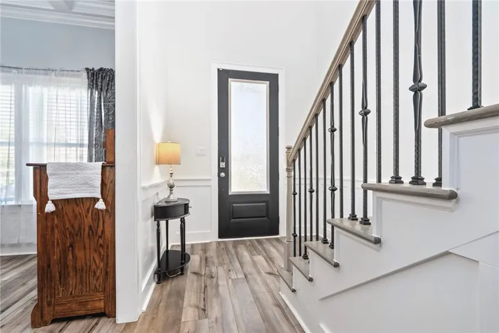 A welcoming entry features durable flooring, a well-crafted staircase, and bright, clean walls.