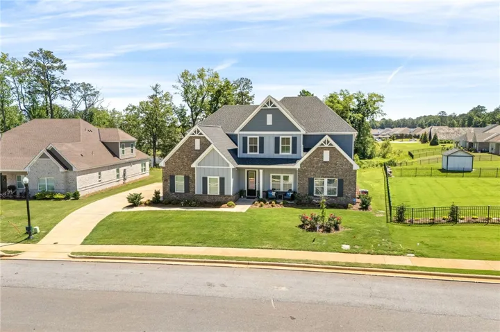 A classic two-story residence presents a meticulously maintained lawn and a welcoming facade.