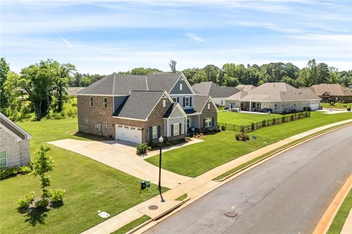 A grand residence featuring an attached garage and meticulous landscaping.