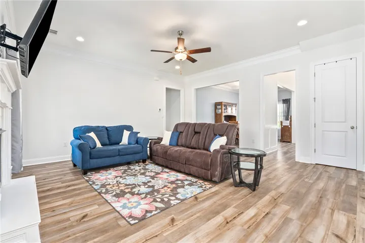Comfortable family room with rich wood-look flooring and recessed illumination.
