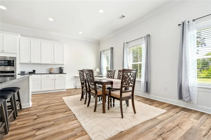 An open-concept living space integrates a well-appointed kitchen with a charming dining area.