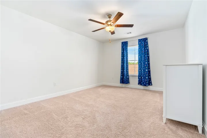 A quiet retreat with a window overlooking the verdant outdoors and a ceiling fan for comfort.