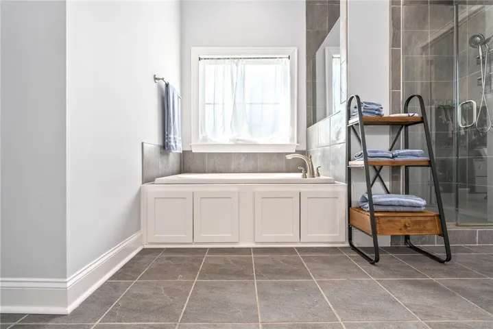 An inviting bathroom offers a deep soaking tub and an adjacent walk-in shower.
