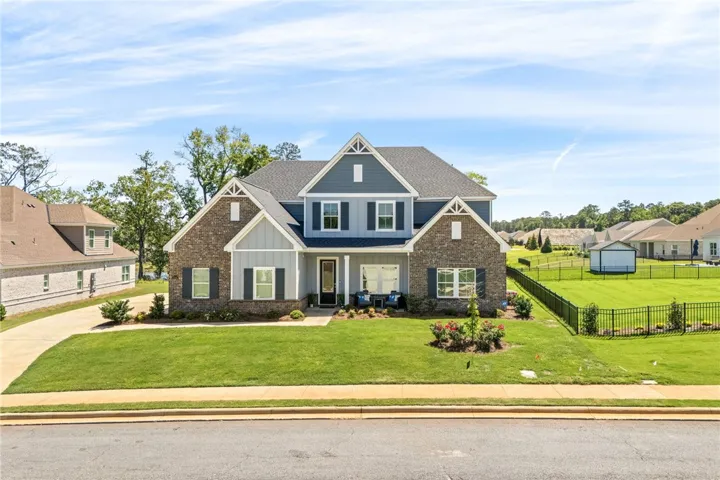 Crafted with brick and siding, this charming residence offers a welcoming street presence with a verdant lawn.